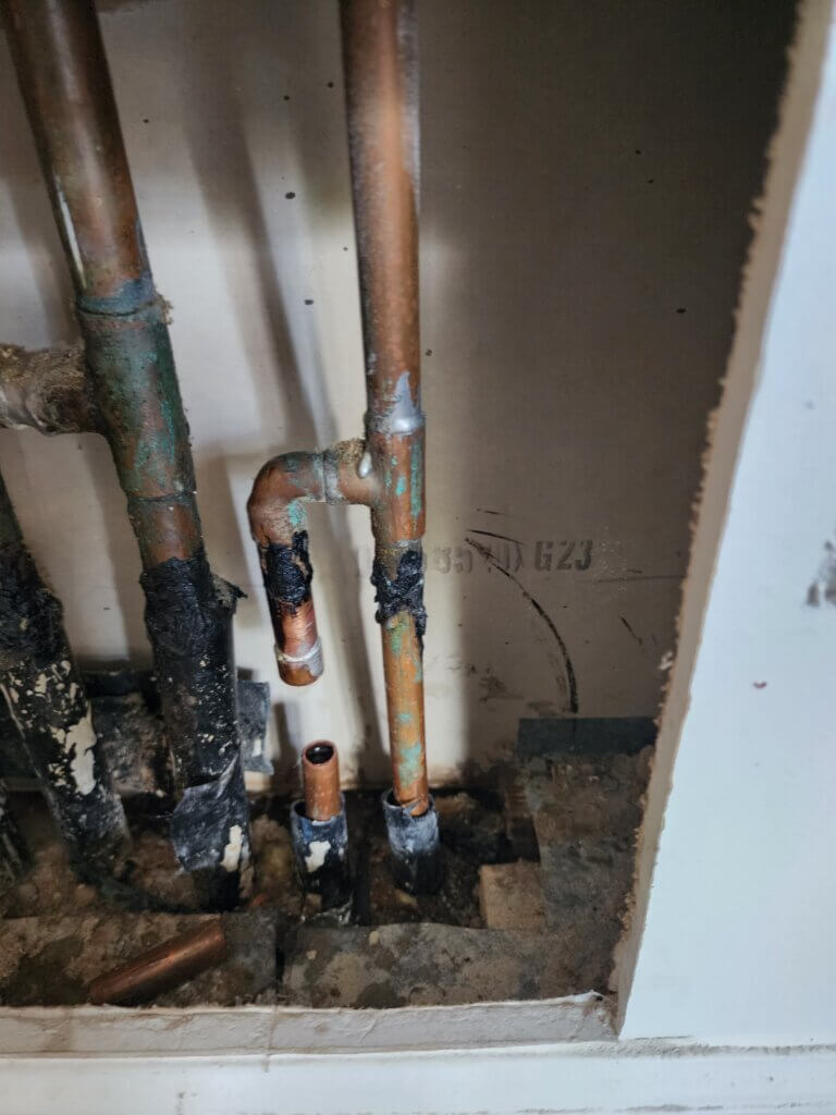 Leaking Copper Pipe in Manifold Inside Bathroom Wall. Line Cap Off Temporally