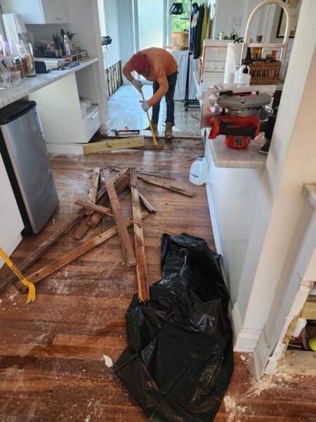 Water-damaged hardwood flooring after a plumbing flood in Broward County, FL—Tip Top Plumbing Company offers expert leak detection and water damage restoration services.