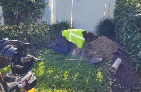 Hydro jetting in action by Tip Top Plumbing at a Broward County residence, using high-pressure water to clean out a clogged sewer line through a ground-level drain cleanout.