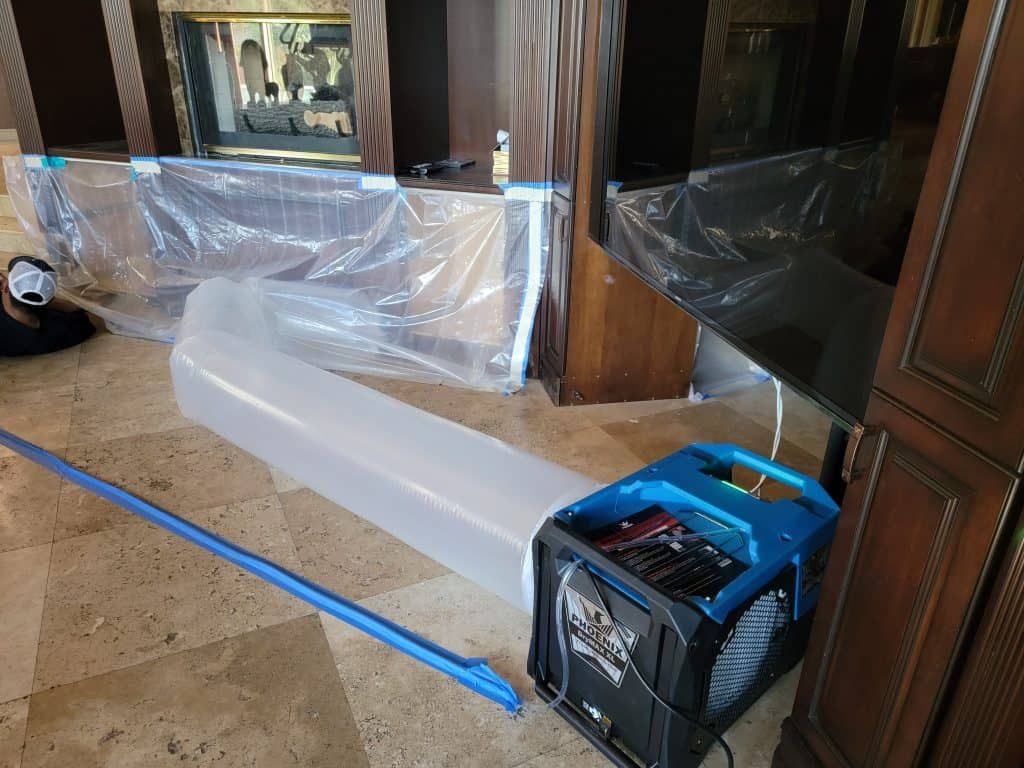 Residential interior with professional drying equipment, including an air mover connected to a plastic drying duct, used in water damage restoration. This image represents Tip Top Plumbing & Restoration’s dry out services in Broward County, FL, offering efficient water removal and mold prevention for homes and businesses.