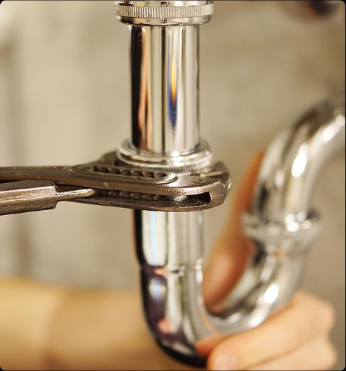 Tip Top Plumbing & Restoration providing expert plumbing and restoration services in Lauderdale-by-the-Sea, FL. The image shows a close-up of a plumber tightening chrome pipes with a wrench, reflecting reliable leak repair and emergency plumbing support.