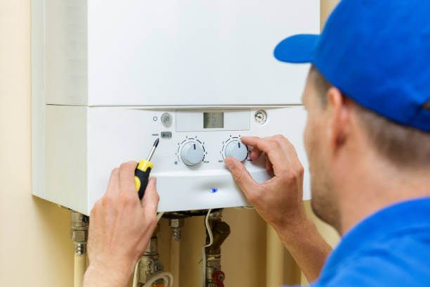 Tip Top Plumbing & Restoration provides professional water heater services in Lazy Lake FL. This image shows a technician adjusting a tankless water heater system during a residential plumbing repair.