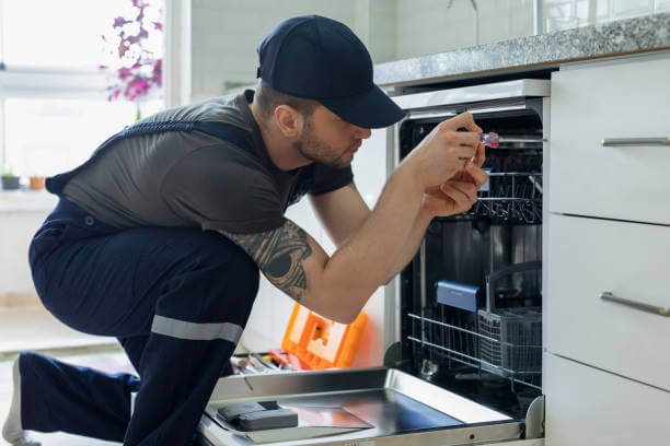 Tip Top Plumbing & Restoration in Margate FL provides expert dishwasher plumbing and repair services. This image shows a technician inspecting a built-in residential dishwasher unit.