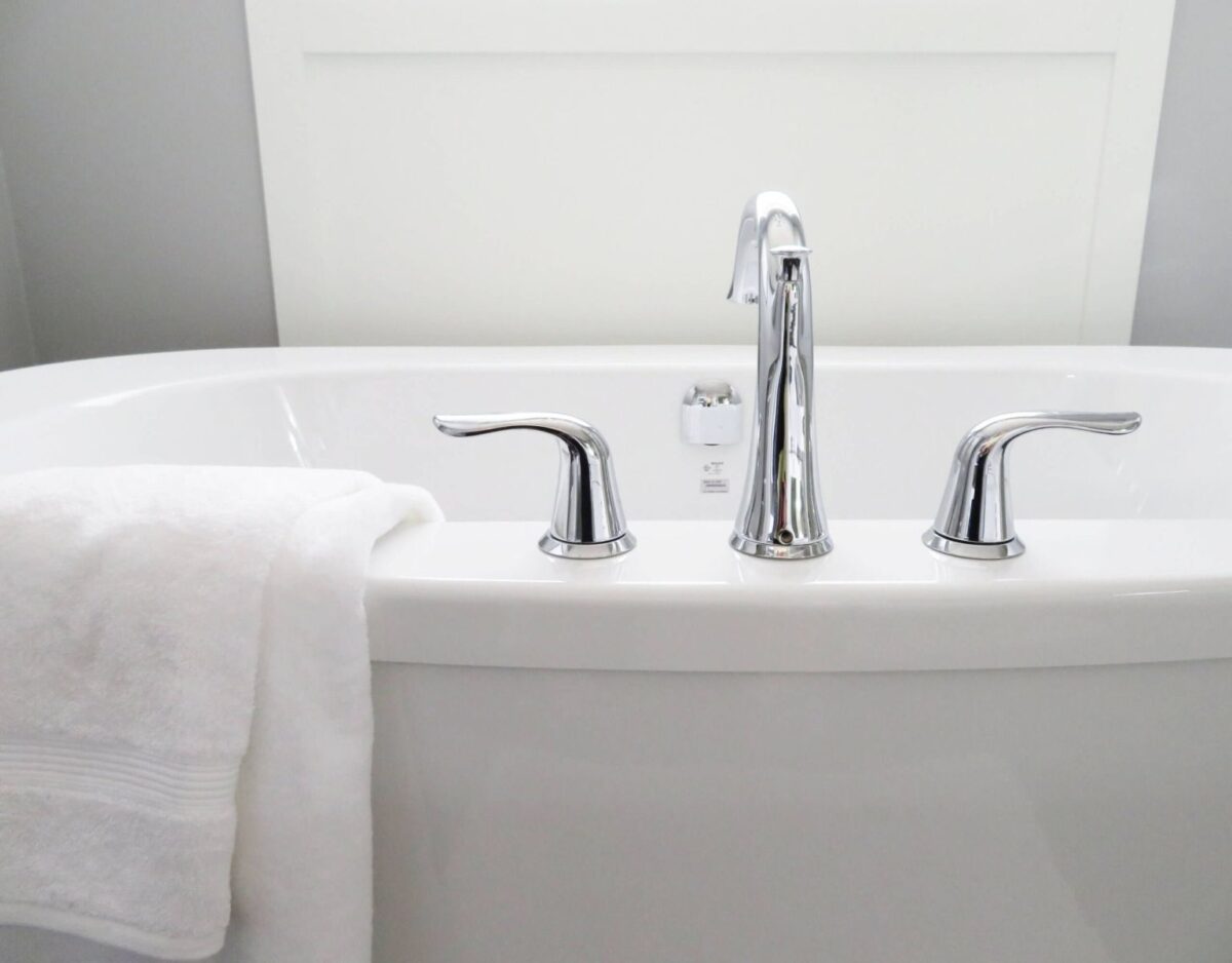 Tip Top Plumbing & Restoration in North Lauderdale FL offers expert bathtub plumbing services. This image shows a modern bathtub with a sleek chrome faucet set and towel.