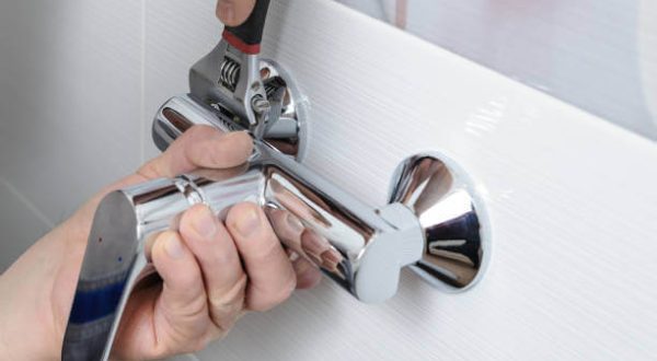 A professional plumber installing or repairing a kitchen faucet, demonstrating Tip Top Plumbing & Restoration’s faucet services in Lauderhill, FL.